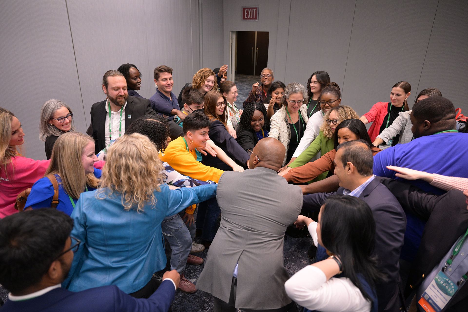 A group of people putting their hands together to kick off a conference.