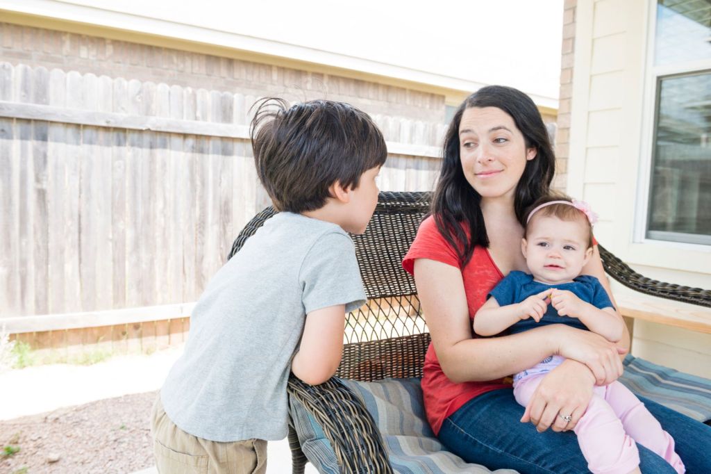 Mom sits in her backyard with son and baby daughter