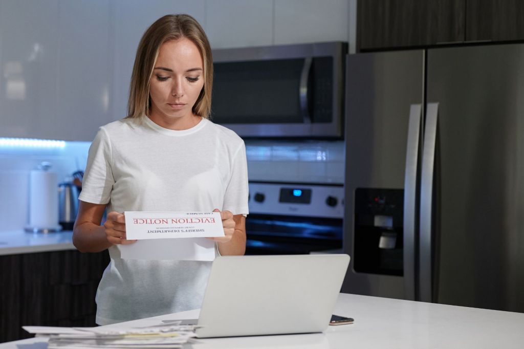 Woman reading eviction notice in kitchen