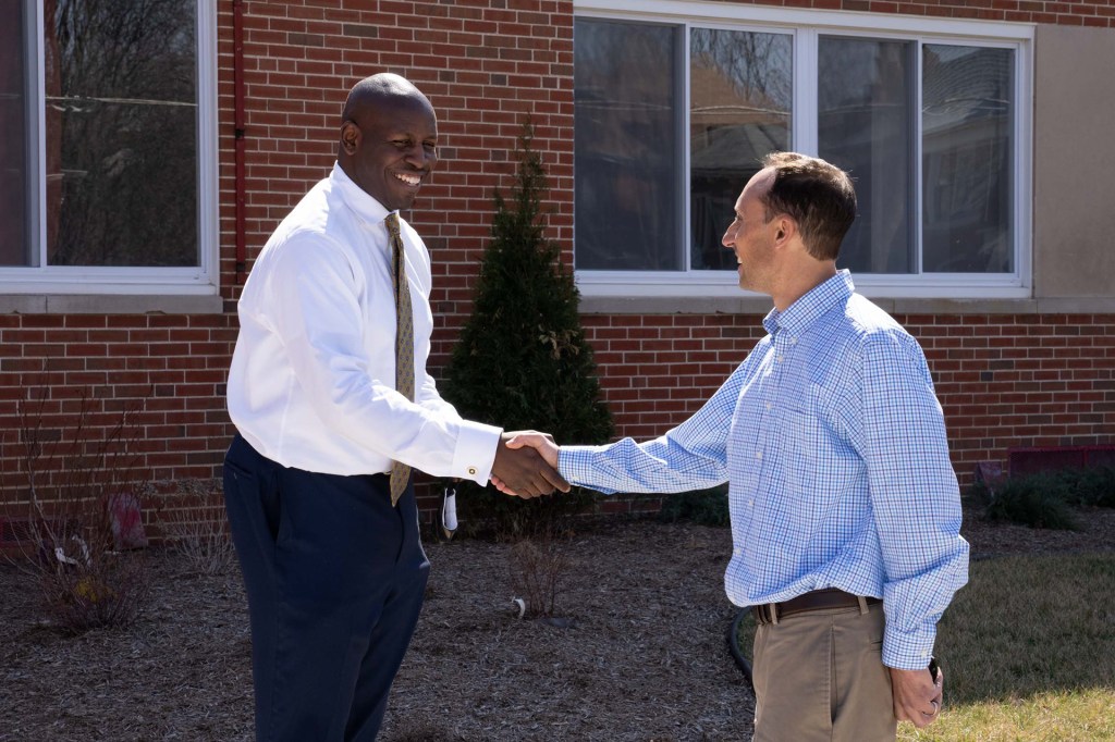 Pastor Andre Alexander shaking hands with Mike Eggleston outside The HUB facility.