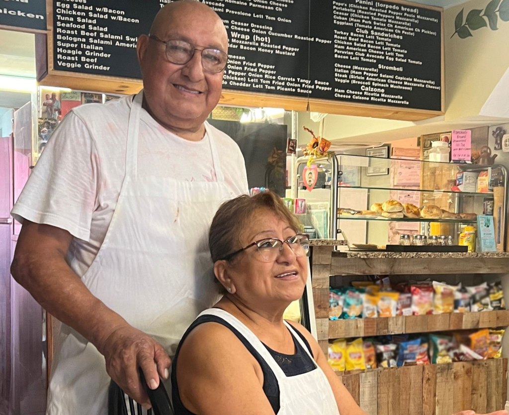 Older couple seated at a deli
