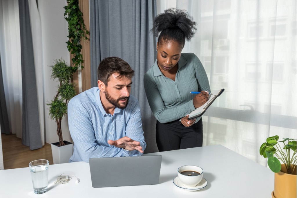Man and woman looking at laptop screen for work