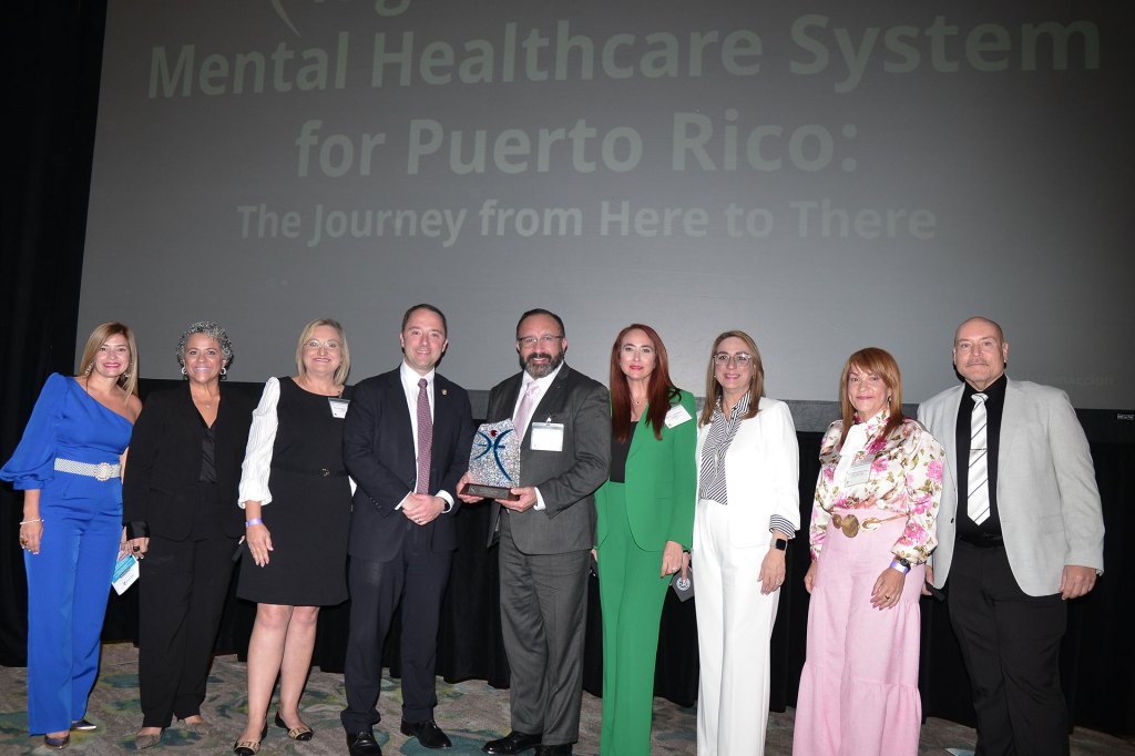 Dennis Romero (center) receives an excellence award from the Puerto Rico Chamber of Commerce for his ongoing championing of behavioral health on the island.