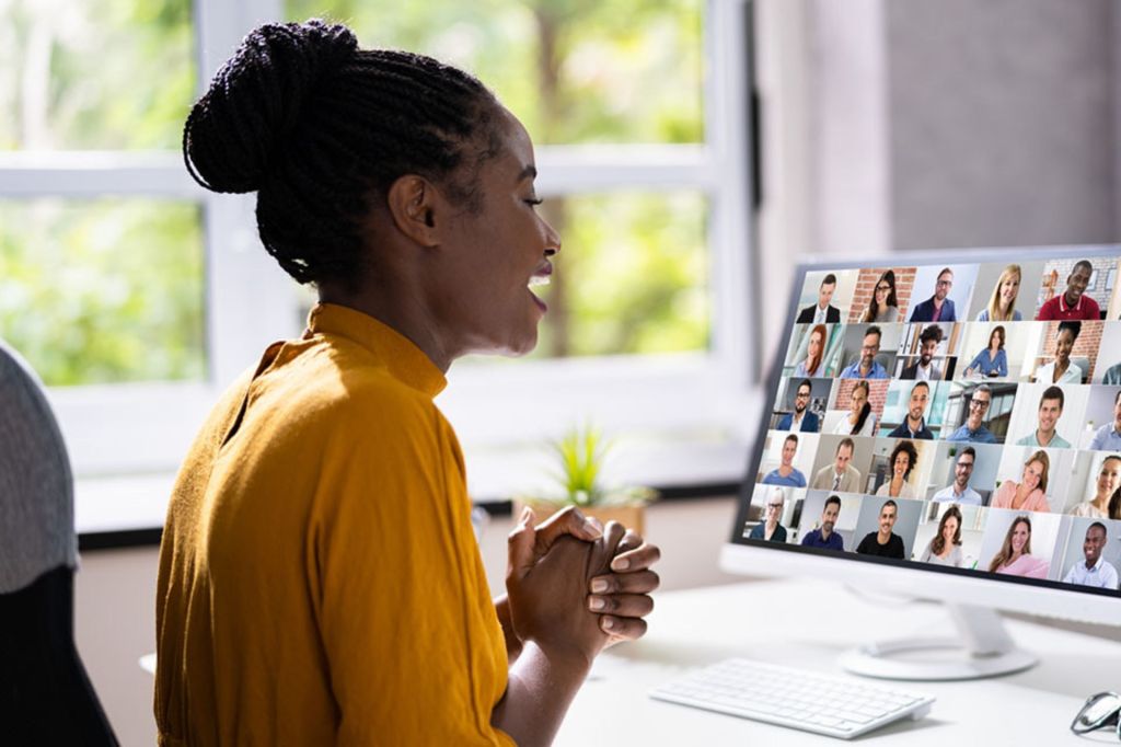 Woman wearing yellow top looking at computer screen.