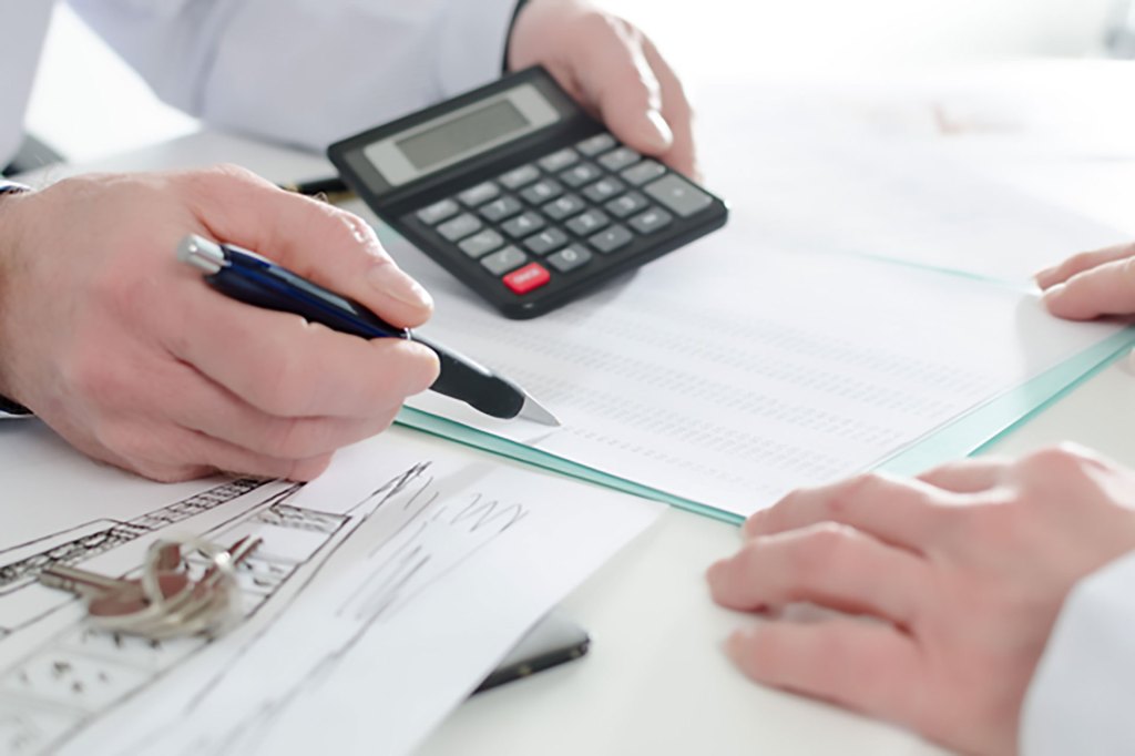 Two people reviewing a financial document together in an office environment.