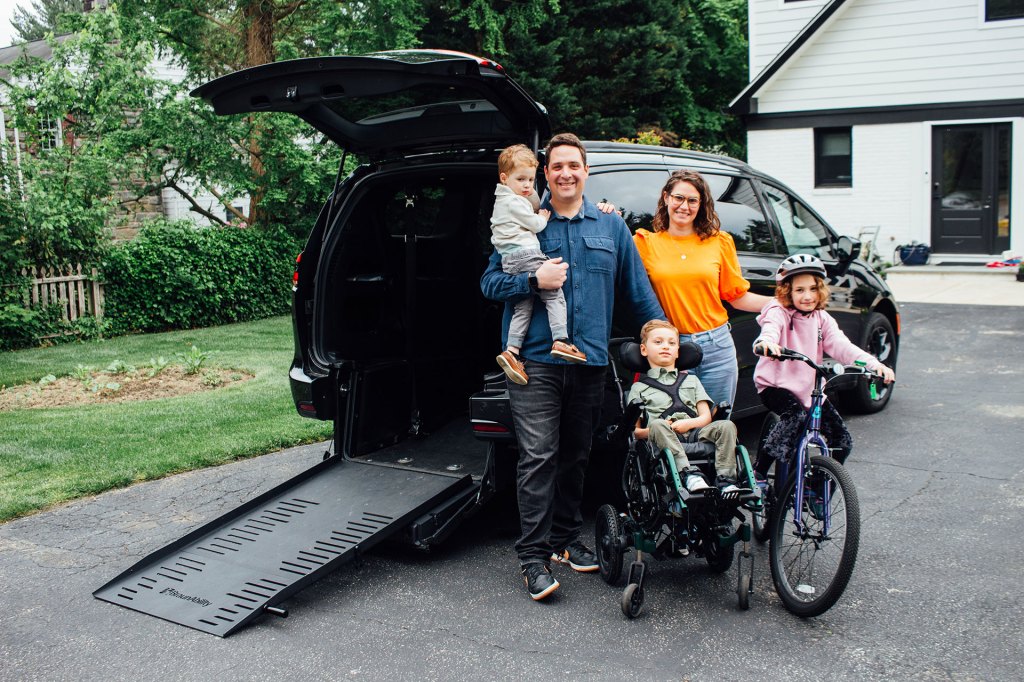 Family standing in front of their adapted mini van to accommodate a wheel chair.