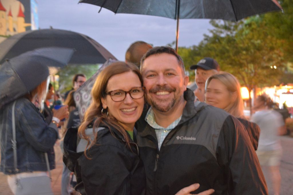 Erika Bell and her husband pose for a picture on a rainy evening