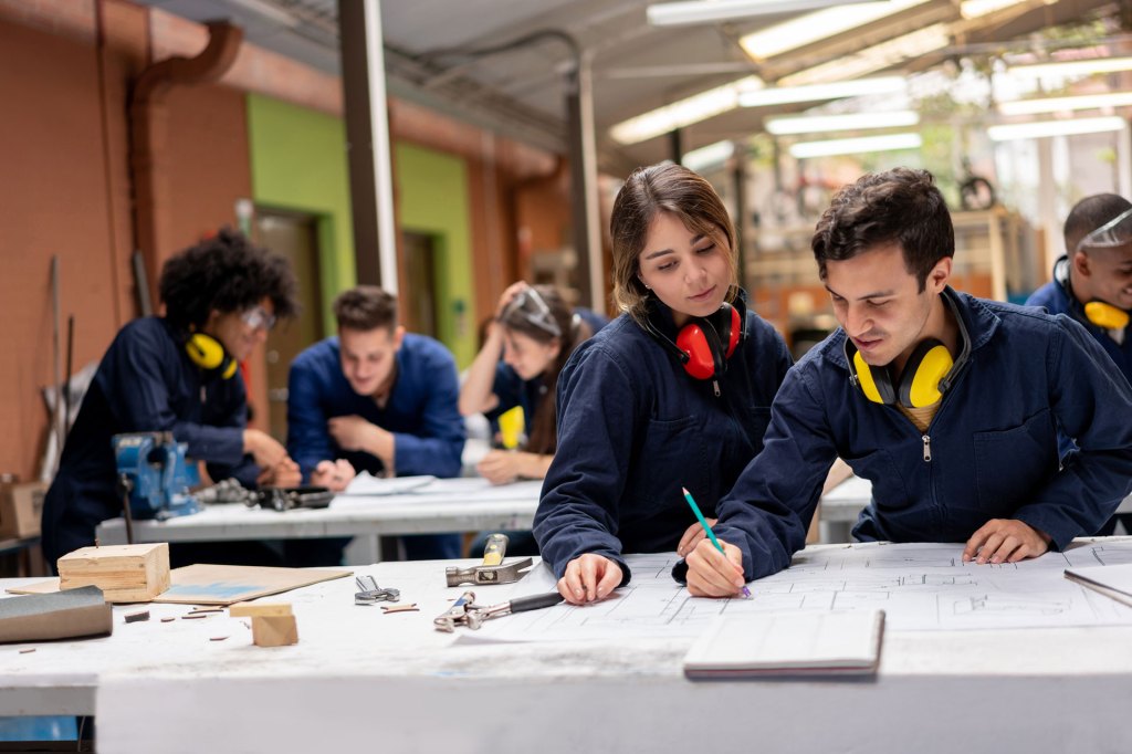 Team of industrial design students working on a project together at school and drawing a furniture sketch