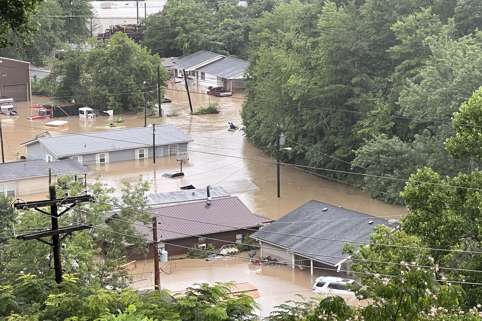 Aerial image of flooding in a Kentucky community. Kayaks search homes to rescue residents.