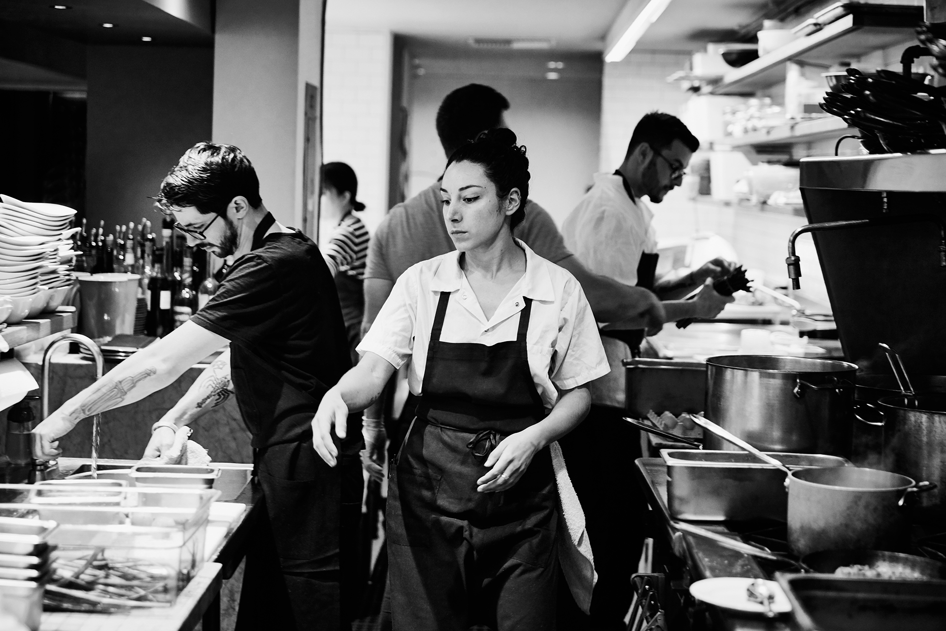 Workers in the kitchen of a restaurant. Washing dishes and prepping food.