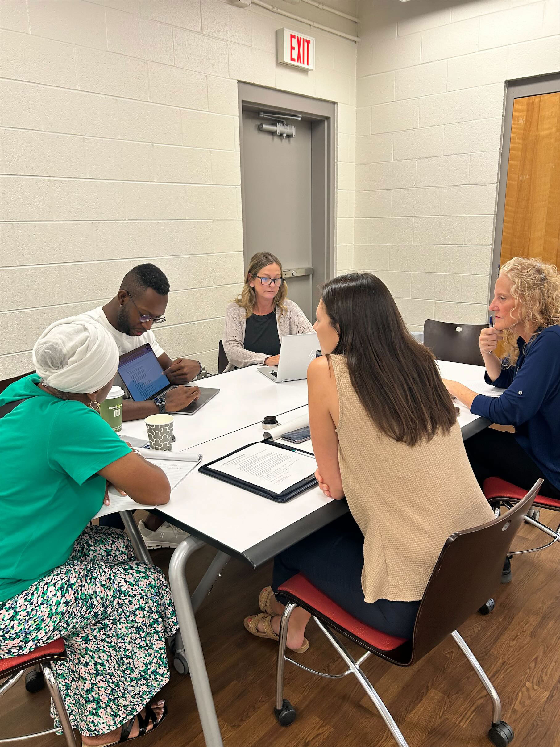 A group of people sit around a table discussing an idea.