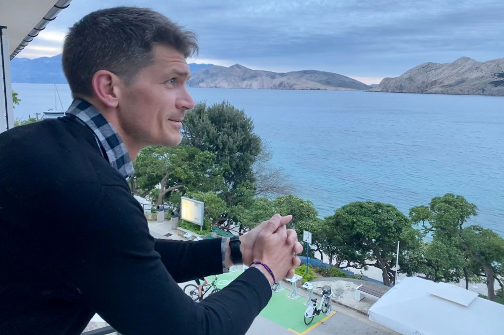 Man looks over a balcony in Baška, Croatia.
