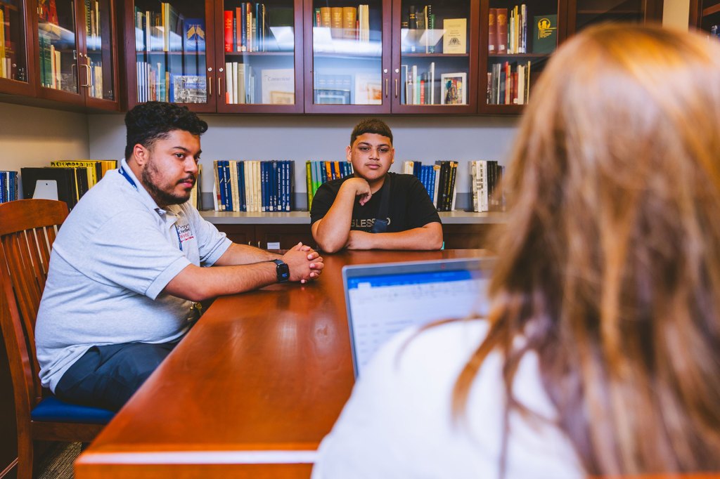 A group of people gather in a library meeting room to talk about workforce development programs