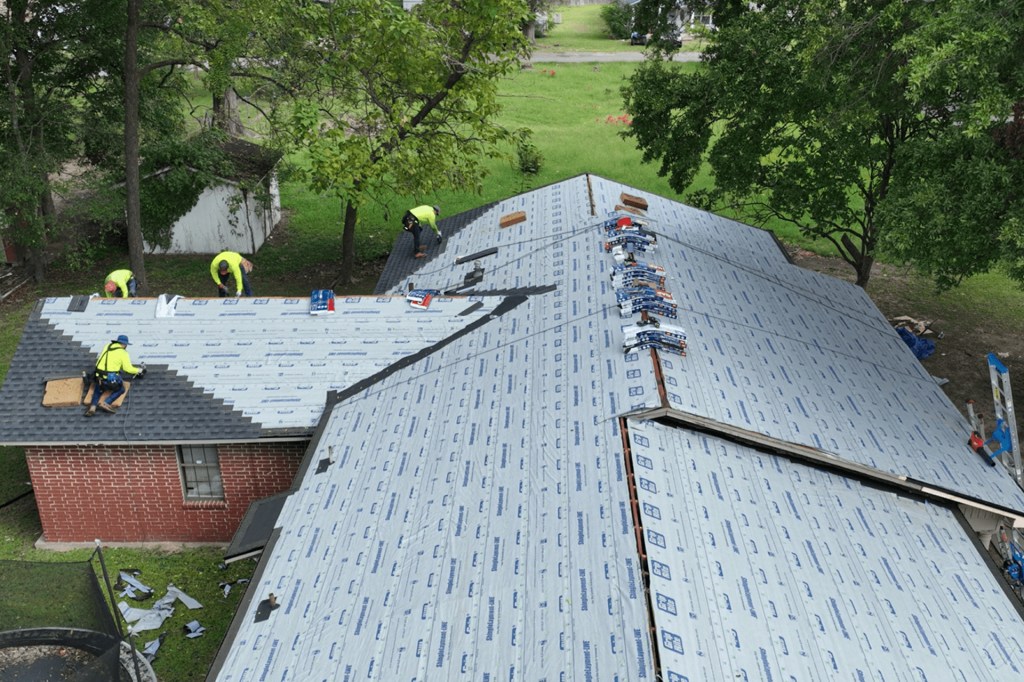 A group of roofers install a new roof on a home.