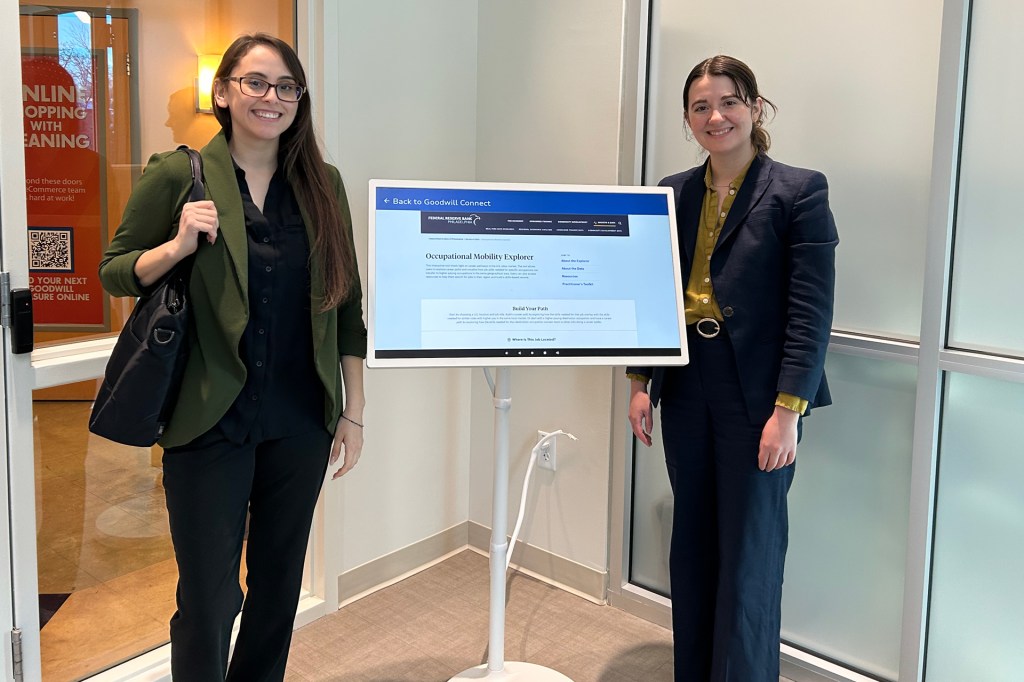 Alma Felix and Theresa Dunne stand next to a Good Will Connect Kiosk showcasing the Occupational Mobility Explorer Tool