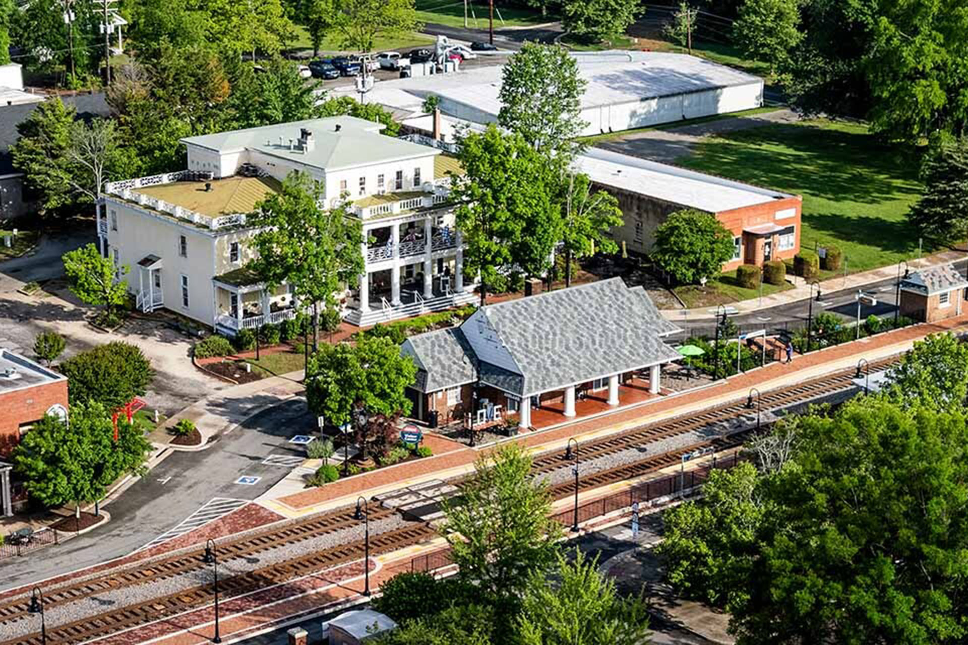 Historic train depot in Ashland, VA. The white building with the grey roof is the Ashland Train Station, which serves Amtrak passengers and freight trains right in the center of town.