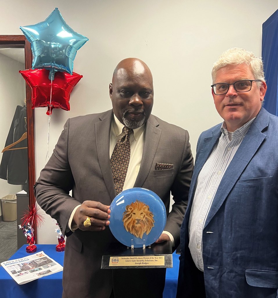 Two men standing next to one another. One man holds a Small Business Award from the U.S. Small Business Administration.