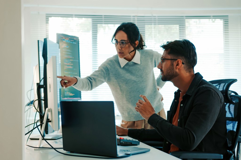 Collaborative Latinx Programmers Discussing Code on Monitor, Remote and Hybrid Work, Artificial Intelligence and Machine Learning